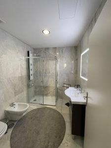a bathroom with a shower and two sinks and a toilet at OPORTO House AL in Maia +35 photos