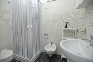 a white bathroom with a sink and a toilet at B&B CASAVACANZE CHIESA MADRE in Carovigno