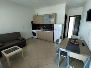 cocina y sala de estar con sofá y mesa en Philoxenia Apartments II, en Plataria