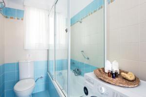 La salle de bains bleue et blanche est pourvue de toilettes et d'une douche. dans l'établissement Thalia's House, à Paleokastritsa 29 autres photos