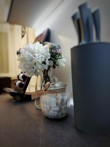 a glass jar with flowers in it on a counter at Apartman Uno in Osijek