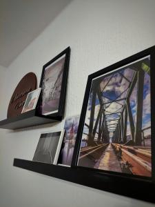 a shelf with pictures and a tv on a wall at Apartman Uno in Osijek