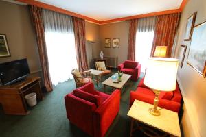 a living room with red chairs and a television at Printania Palace Hotel in Broummana