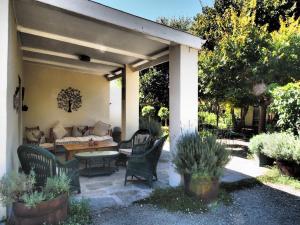 a patio with a couch and a table and chairs at Cypress Cottage in Graaff-Reinet