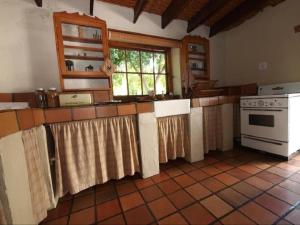 a kitchen with a counter with a stove and a window at Cypress Cottage in Graaff-Reinet