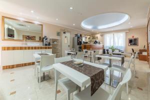 a kitchen and dining room with white tables and chairs at Hotel Riviera Fiumicino in Fiumicino