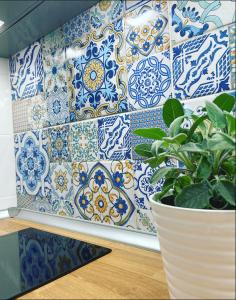 a wall covered in blue and white tiles with a plant at La Maiolica in Anacapri
