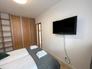 małą sypialnię z łóżkiem i telewizorem z płaskim ekranem w obiekcie AL-DOM Apartament Ogrodowa Bocianie Gniazdo z garażem w Kołobrzegu