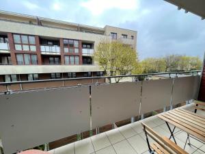 balkon z białą ścianą i budynkiem w obiekcie AL-DOM Apartament Ogrodowa Bocianie Gniazdo z garażem w Kołobrzegu
