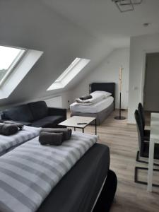 Ferienwohnung Apartment - Free Parking - WiFi - Kitchen في إيسن: غرفة معيشة بها سريرين وأريكة