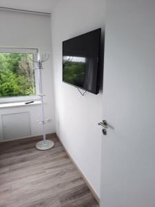 Ferienwohnung Apartment - Free Parking - WiFi - Kitchen في إيسن: غرفة مع تلفزيون بشاشة مسطحة على الحائط