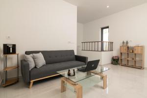a living room with a couch and a table with a laptop at Solis Ortus Villa! in Zakynthos Town