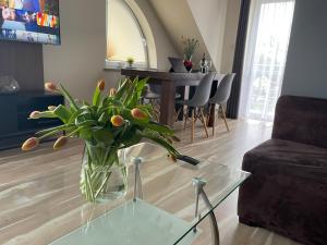 a vase of flowers sitting on a glass table in a living room at Baltic Sun SPA in Rewal