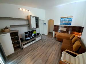 a living room with a couch and a flat screen tv at Tea-Dream house in Cesarica
