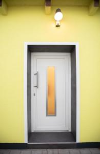 una puerta blanca en una pared amarilla con una luz en Chillzimmer, en Duisburg