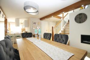 une salle à manger avec une table, des chaises et une horloge dans l'établissement Apartament Daisy, à Szczawno-Zdrój