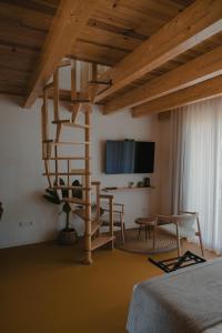 a bedroom with a wooden spiral staircase in a room at Casinhas de Santo António in Alter do Chão