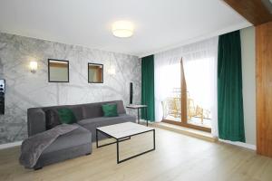 uma sala de estar com um sofá e uma mesa em Apartament Daisy em Szczawno-Zdrój