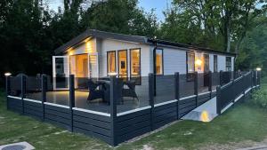 a tiny house with a deck in the yard at Luxury Lodge - Hoburne Devon Bay in Paignton