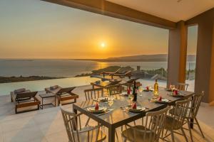 een eetkamer met een tafel en uitzicht op de oceaan bij Echos Villa in Argostoli