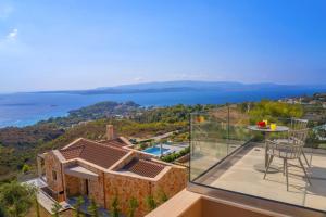 een huis met een balkon met uitzicht op het water bij Echos Villa in Argostoli
