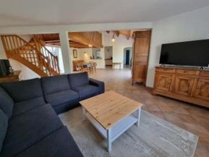 uma sala de estar com um sofá azul e uma mesa em MAISON OROUET PISCINE 4 CHAMBRES em Saint-Jean-de-Monts