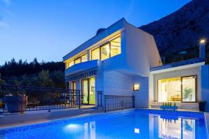 a house with a swimming pool in front of it at Villa Amare, Makarska in Makarska