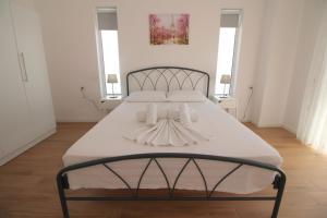 - une chambre avec un lit doté d'un couvre-lit blanc dans l'établissement Nefeli Apartments, à Saranda
