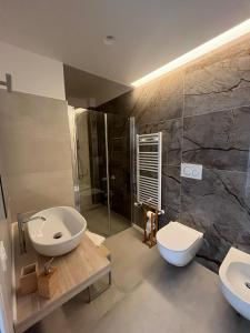 La salle de bains est pourvue d'un lavabo, de toilettes et d'une douche. dans l'établissement B&B Casa Laforgia Soffio Mediterraneo, à Polignano a Mare