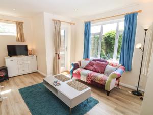 a living room with a couch and a table at Straw Cottage in Swindon