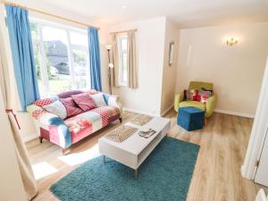 a living room with a couch and a table at Straw Cottage in Swindon