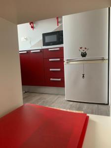 トリノにあるNonno Pininのキッチン(赤いキャビネット、白い冷蔵庫付)