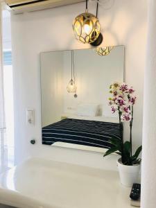 espejo en una pared sobre una cama en una habitación en Taki's Guests en Naxos