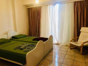 a bedroom with a bed and a chair and a window at The salty studio in Rethymno Town