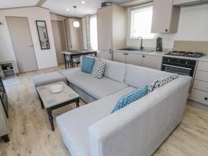 a living room with a couch and a kitchen at Dreams & Streams in Morpeth