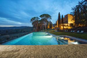 een uitzicht op een zwembad in de nacht met een villa bij Castello di Spaltenna Exclusive Resort & Spa in Gaiole in Chianti
