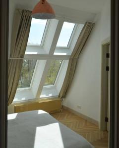 a bedroom with two windows and a bed in it at Luxury apartment with a balcony and view in Riga Old Town in Riga +57 photos