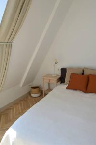 a bedroom with a white bed and a table at Luxury apartment with a balcony and view in Riga Old Town in Rīga