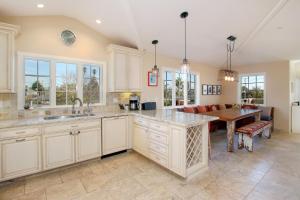 a kitchen with white cabinets and a dining room at Pleasure Point Retreat in Santa Cruz