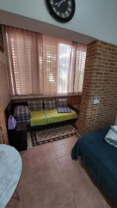 a room with a bed and a clock on the wall at Guest House Orlihome in Haifa