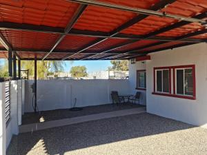 a patio with awning and a table on a white wall at VERY SECURED HOUSE 7 MINUTES FROM THE BEACH in Puerto Peñasco