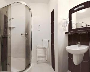 a bathroom with a shower and a sink and a toilet at Hotel Vitalia in Boszkowo