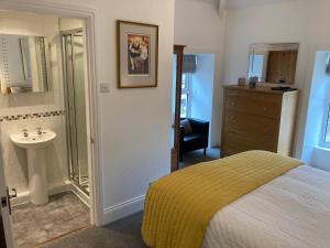 a bedroom with a bed and a bathroom with a sink at Ebor House in Hawes