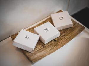 three white boxes on a wooden tray on a table at Hotel Vitalia in Boszkowo