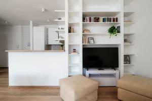 a living room with white shelves and a tv at Palace Apartment by Quokka 360 - 2 minutes from Lugano Lido in Lugano
