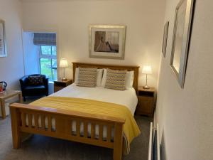 een slaapkamer met een bed en een stoel bij Ebor House in Hawes