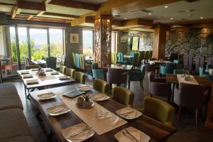 a dining room with wooden tables and green chairs at Zoo Misic Prenoćište in Vranje