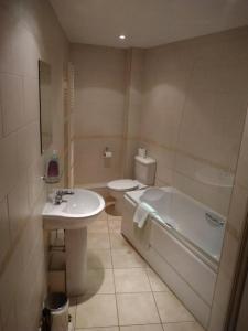 a bathroom with a sink and a tub and a toilet at Victoria Cloisters Apartments in York