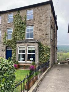 a brick house with ivy on the side of it at Ebor House in Hawes