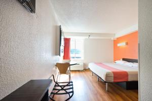 a hotel room with a bed and a table and a chair at Motel 6-Springfield, DC - Washington Southwest in Springfield